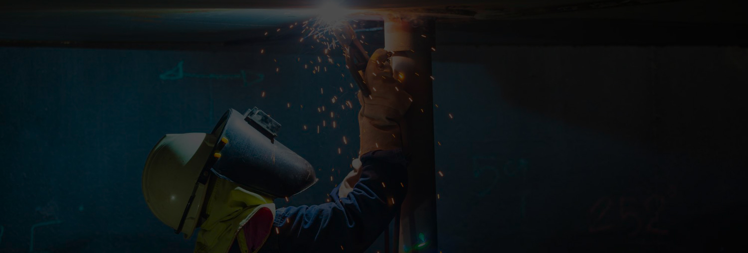 A handheld fiber laser welder being used on thin metal stock in a fabrication shop